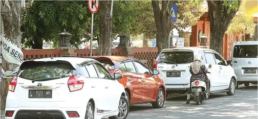  ?? BOY SLAMET/JAWA POS ?? BUTUH SOLUSI: Banyak mobil yang parkir di bahu Jalan Majapahit, depan RSUD Sidoarjo, kemarin. Padahal, di lokasi itu terdapat rambu larangan parkir.