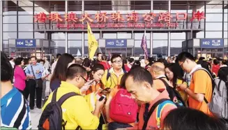  ?? KATHY ZHANG / CHINA DAILY ?? A small crowd is formed early on Wednesday at the Zhuhai Port of the Hong Kong-Zhuhai-Macao Bridge. They wait for clearance before taking shuttle bus to Hong Kong.