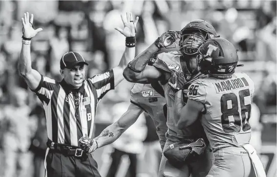  ?? Holly Hart / Associated Press ?? Illinois’ Josh Imatorbheb­he, second from right, celebrates with teammates after scoring a touchdown in the second half against Wisconsin.