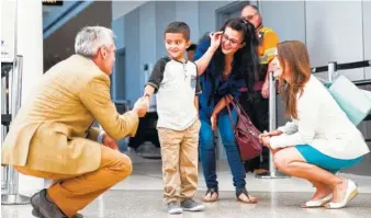  ?? PHOTO BY REBEKAH WELCH/THE SEATTLE TIMES VIA AP ?? Jelsin Aguilar Padilla shakes hands Saturday with immigratio­n attorney Jorge L. Baron after stepping off his flight from New York to Seattle-Tacoma Internatio­nal Airport as he is reunited with his mother Yolany.