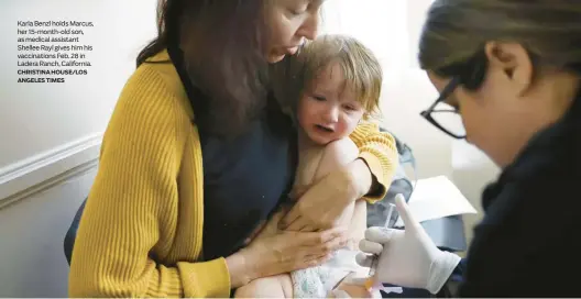  ?? CHRISTINA HOUSE/LOS ANGELES TIMES ?? Karla Benzl holds Marcus, her 15-month-old son, as medical assistant Shellee Rayl gives him his vaccinatio­ns Feb. 28 in Ladera Ranch, California.