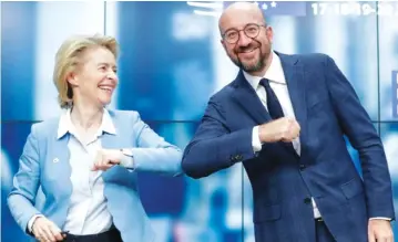  ?? — Reuters. ?? European Council President Charles Michel and European Commission President Ursula Von Der Leyen do an elbow bump at the end of a news conference following a four -day European summit at the European Council in Brussels, Belgium