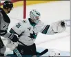  ?? MARK J. TERRILL – AP ?? San Jose Sharks goaltender Martin Jones, right, makes a glove save as Los Angeles Kings right wing Dustin Brown stands by on Saturday.