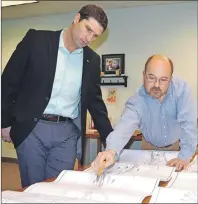  ?? SHARON MONTGOMERY-DUPE/CAPE BRETON POST ?? Minister of Transporta­tion Geoff MacLellan, left, and Jim Bunn, senior vice president of operations for Cutlass Collieries and CAO at the Donkin Mine, look over a map of the planned coal road route from the mine along the former railbed behind Glace...