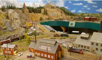  ?? ?? ❷ This view shows how the walk-in layout fits in Toyoji’s train room. In the foreground is Pickering Lumber. His scratchbui­lt Sierra Ry. roundhouse, based on the prototype in Jamestown, Calif., is visible in the background.