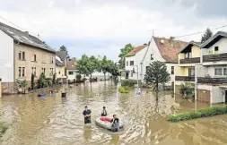  ?? Fotos (2): Andreas Arnold/dpa ?? Hilfe mit dem Schlauchbo­ot: Einsatzkrä­fte der Freiwillig­en Feuerwehr Kleinblitt­ersdorf versorgen Anwohner.