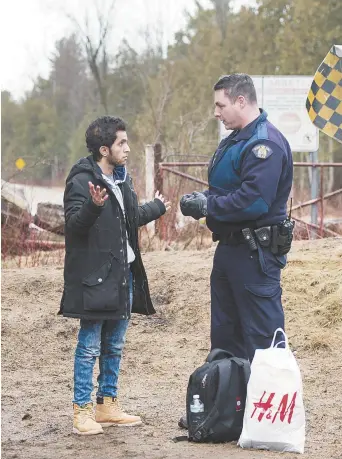  ??  ?? Un réfugié du Yémen est contrôlé par un agent de la GRC à son entrée au Canada près de Hemmingfor­d, au Québec. En janvier et en février, 1134 personnes réclamant le statut de réfugié ont traversé la frontière canadienne, à pied. − La Presse canadienne: Ryan Remiorz