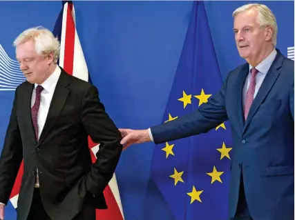  ??  ?? Hang on, you’re not leaving yet: EU negotiator Michel Barnier grabs David Davis yesterday...