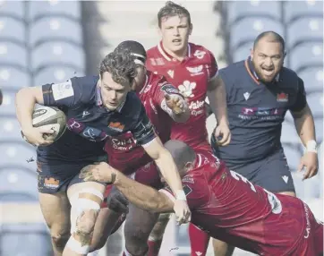  ??  ?? 0 Edinburgh winger Darcy Graham is tackled by Scarlets’ Pieter Scholtz during Saturday’s clash