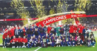  ?? Reuters ?? Barcelona players and staff celebrate with the trophy after winning the King’s Cup final aganinst Sevilla.