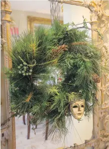  ??  ?? Above: Hanging from a carved wooden Italian mirror is a wreath of greenery decorated with a mask from the Carnival in Venice.