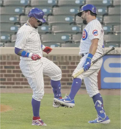  ?? NAM Y. HUH/AP ?? Javy Baez (left) celebrates with Kyle Schwarber after hitting a solo home run in the intrasquad game Friday at Wrigley Field.