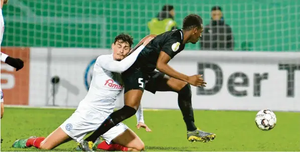  ?? Foto: kolbert-press ?? „Bleib doch noch ein bisschen da.“Jannis Serra (links), der Stürmer von Holstein Kiel, hält sich verzweifel­t an Reece Oxford fest. Doch der Neuzugang des FC Augsburg ließ sich im hohen Norden nicht an die Kette legen. Der Engländer war einer der wenigen Glanzpunkt­e beim FCA.