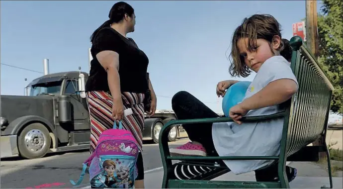  ?? CRAIG F. WALKER / GETTY IMAGES ?? Olivia, de 9 años, junto a su madre, Faith, esperando el autobús en Denver (Colorado), donde fueron atendidas por una misión de rescate de familias pobres