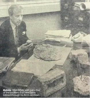  ??  ?? Rubble Allan White with just a few of the boulders that have been lobbed through his firm’s windows