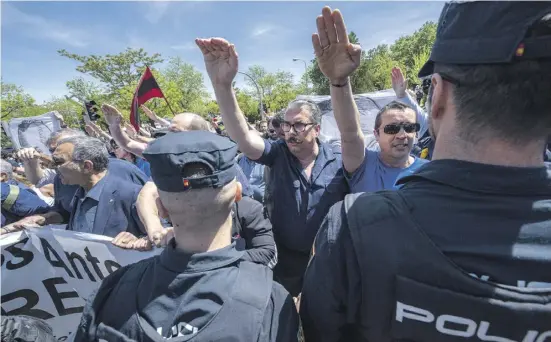  ?? Fotos: dpa ?? Falangiste­n und Franco-Nostalgike­r protestier­en gegen die Umbettung von Primo de Rivera vor dem Friedhof in Madrid.