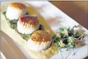  ??  ?? Diver scallops with corn coulis and lemon grass cilantro salsa is on the small plates menu.