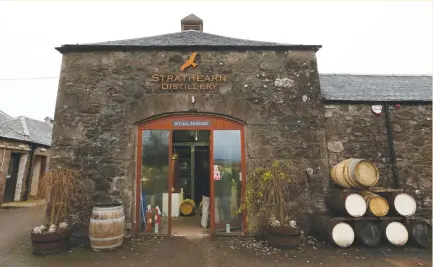  ?? (Russell Cheyne/Reuters) ?? VISITORS STAND in the doorway of Strathearn Distillery in Methven last week. Gin can be produced in about a week, whereas whiskey takes at least three years.