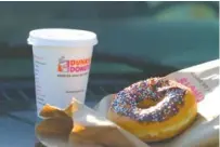  ?? GETTY IMAGE ?? A cup of Dunkin’ Donuts coffee and a chocolate glazed donut are shown.