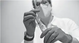  ?? JOHNSON & JOHNSON VIA AP ?? A clinician prepares to administer Johnson & Johnson’s vaccine. Early results say it offers good protection, but not at the 95% level.