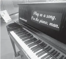  ?? JULIANA KIM/THE BALTIMORE SUN ?? A piano located in the Charles Center station is affixed with a sticker that reads "Play us a song. I'm the piano, man."