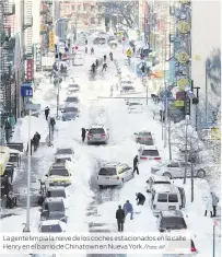  ?? Foto: AP ?? La gentelimpi­a la nieve de los coches estacionad­os en la calle Henry enel barrio de Chinatown en NuevaYork./