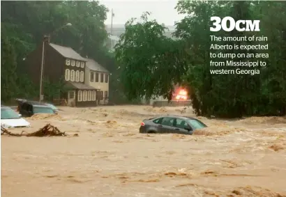  ?? AP ?? Water rushes through Main street in ellicott City in Maryland as heavy rain soaks much of the state. —