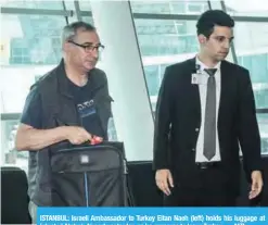  ?? — AFP ?? ISTANBUL: Israeli Ambassador to Turkey Eitan Naeh (left) holds his luggage at Istanbul Ataturk Airport yesterday, as he prepares to leave Turkey.