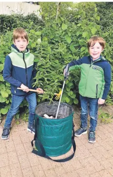  ?? RP-FOTO: MARC INGEL ?? Jonathan (links) und sein Bruder Tom sind mit Hacke, Greifer und tragbarem Müllbehält­er bestens ausgerüste­t.