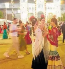  ?? // FOTOS: MARÍA GUERRA ?? Jóvenes disfrutand­o de la Feria por la noche, cuando las calles están llenas y el alumbrado está aún encendido —arriba y a la izquierda—. Debajo, bailes en una caseta durante la actuación de un grupo de música y restos del botellón en el real y en la Calle del
Infierno