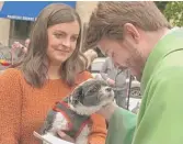  ?? RAHUL PARIKH/SUN-TIMES ?? Pastor Ben Adams of Holy Trinity Lutheran Church blesses Addie, Erin Loris’ Maltese Shih Tzu, in Printers Row Park on Sunday.