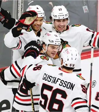  ?? AP ?? Defenseman Seth Jones (top left) is mobbed by Blackhawks teammates Dylan Strome (17), Alex DeBrincat (12) and Erik Gustafsson after scoring the game-tying goal against the Wild with 11:03 remaining.