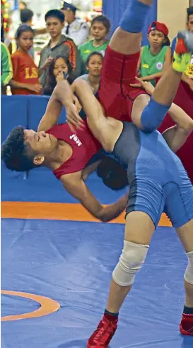  ?? PSC PHOTO ?? Elmer Edano (in blue) of Tagum City battles it out with Davao del Norte’s Noel Keith Castillano during the 2016 Batang Pinoy wrestling match at 66kg in Tagum, Davao del Norte.