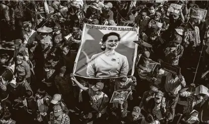  ?? New York Times ?? A picture of deposed leader Aung San Suu Kyi is carried by demonstrat­ors marching against the military coup in Yangon, Myanmar. Saturday was the birthday of Suu Kyi’s father, Gen. Aung San, who was the founder of Myanmar’s armed forces.