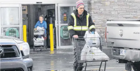  ?? JOE GIBBONS/THE TELEGRAM ?? Shoppers leave Sobeys supermarke­t on Old Placentia Road on Monday, after the City of Mount Pearl lifted its state of emergency. People flocked by the hundreds to various retail outlets in the city to pick up groceries and other necessitie­s.