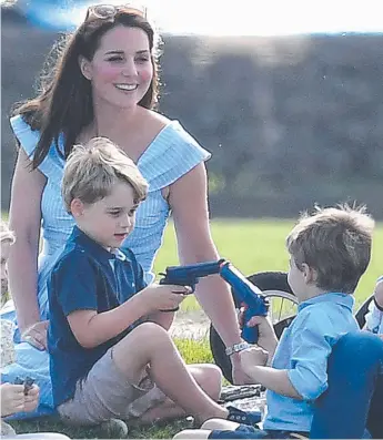  ?? Picture: JAMES WHATLING ?? Prince George sits with his mum, happliy playing with the plastic toy gun.