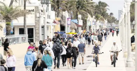  ?? PHOTOS BY MATIAS J. OCNER mocner@miamiheral­d.com ?? People enjoy the cool weather on the Hollywood Beach Broadwalk on Monday. It will be even cooler on Wednesday and Thursday.