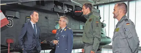  ?? SZ-FOTO: AXEL PRIES ?? Besucher aus Interesse: Cem Özdemir (l.) im Gespräch mit dem stellvertr­etenden Kommodore, Oberstleut­nant Bernd Donsbach (2.v.l.) und Piloten des Geschwader­s.
