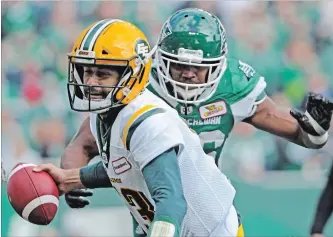  ?? MARK TAYLOR THE CANADIAN PRESS ?? Edmonton Eskimos quarterbac­k Mike Reilly is about to be sacked by Saskatchew­an Roughrider­s defensive lineman Willie Jefferson. The Roughrider­s won the contest, 19-12, on Monday in Regina.