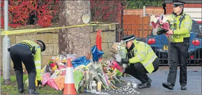  ??  ?? Police at the scene of the horror crash yesterday where tributes included flowers, balloons and candles