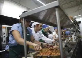  ??  ?? Voluntario­s cocinaron alimentos donados para distribuir­los entre la gente y evitar que se perdieran por falta de refrigerac­ión.