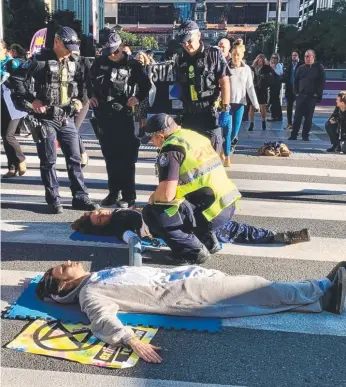  ?? Picture: JASMINE LILL ?? Extinction Rebellion protesters block Queen Street in Brisbane during peak hour.