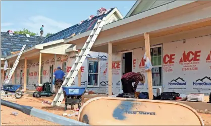  ?? John Bailey ?? Workers put shingles on the roofs of duplexes early Wednesday. The housing authority board of directors proposed rates of $613 a month for the one-bedroom units and $755 for the two-bedroom units in the homes on Charlton Street near the Summervill­e Park neighborho­od.