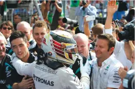  ??  ?? Mercedes driver Lewis Hamilton of Britain celebrates with teammates after winning the Hungarian Formula One Grand Prix at the Hungarorin­g racetrack Photo: AP