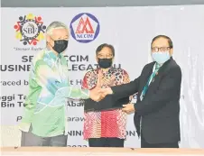  ?? — Penerangan photo ?? NCCIM president Dato Low Kian Chuan (left) exchanges MoU documents with SBF president Datuk Abang Abdul Karim Tun Abang Openg witnessed by Abang Johari.