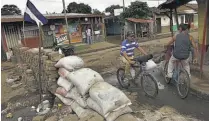  ??  ?? Nuevo fuerte. Personas caminan frente a una barricada en el barrio indígena de Monimbó, Masaya.