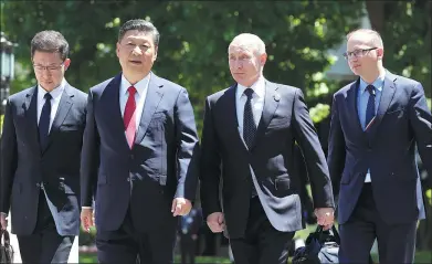  ?? WU ZHIYI / CHINA DAILY ?? President Xi Jinping and his Russian counterpar­t Vladimir Putin take a stroll after their meeting in the Diaoyutai State Guesthouse in Beijing on Sunday morning.