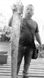  ??  ?? Photo of a fisherman holding the dragon fish he caught which has gone viral.