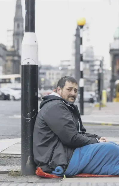  ??  ?? 0 A homeless man sits on the street in Edinburgh in the wake of the lockdown while local authoritie­s