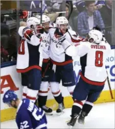  ?? FRANK GUNN — THE CANADIAN PRESS VIA AP ?? Washington Capitals center Marcus Johansson (90), celebrates with right wing Justin Williams (14) center Evgeny Kuznetsov (92) and left wing Alex Ovechkin (8) after scoring against the Maple Leafs during overtime to take down host Toronto in Game Sunday.